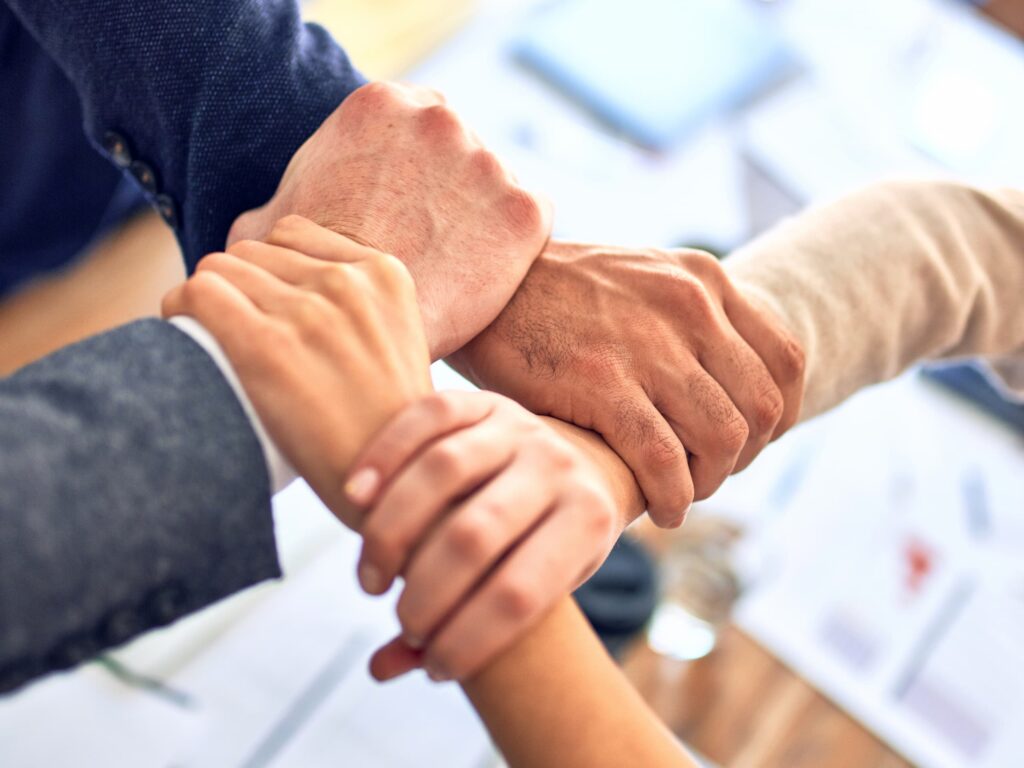 Four hands holding wrists in office